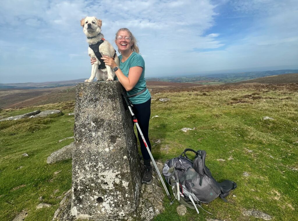 A walk in the parks - Jen and Cookie on a trig point in Dartmoor